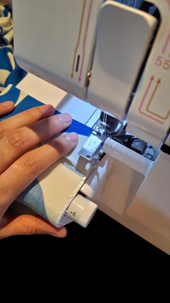 Hands guiding fabric through a sewing machine